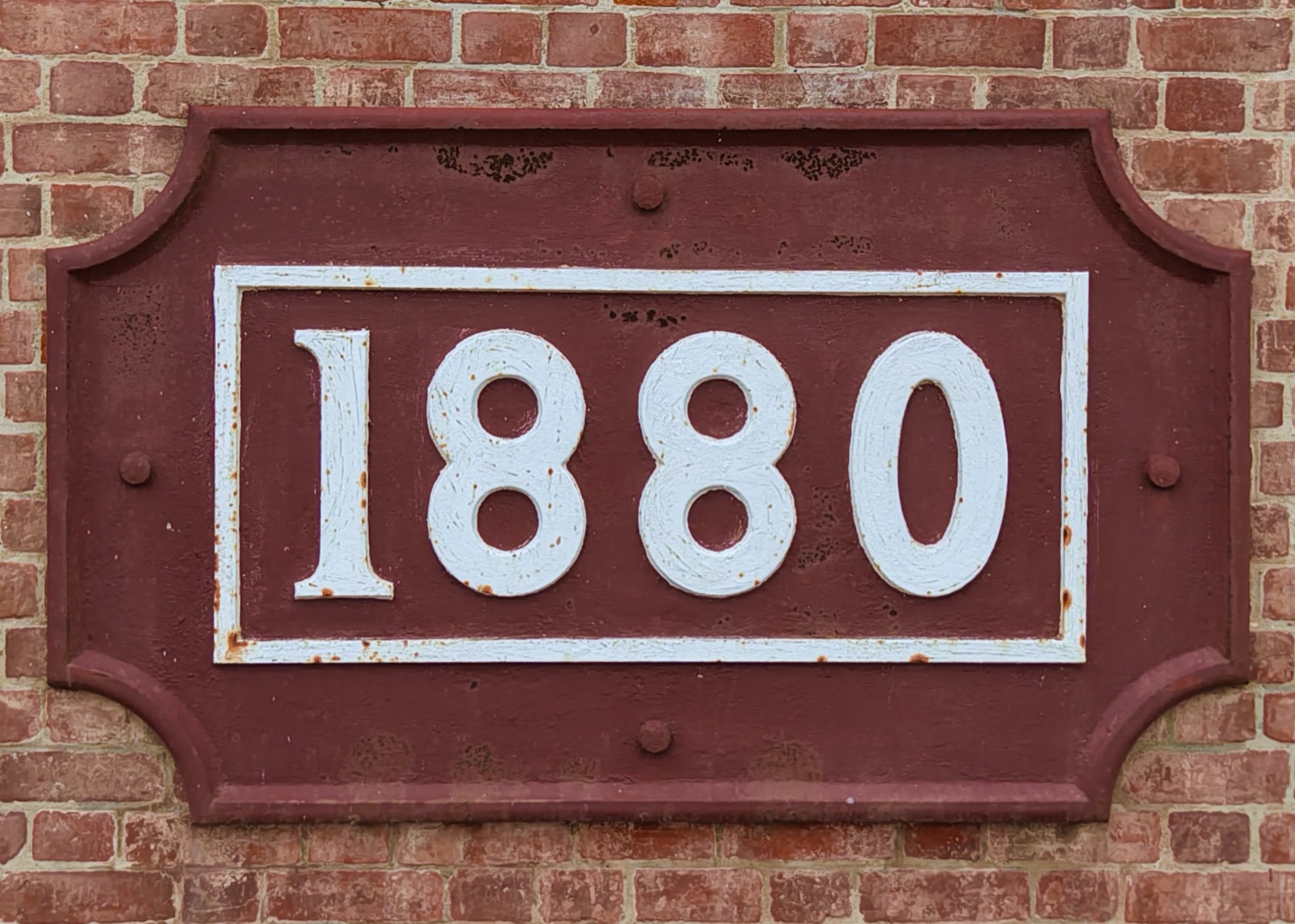 The cast plaque on the tower's brickwork reading 1880