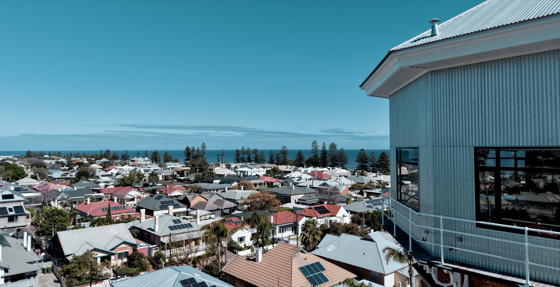The outlook from the tank level over Semaphore's rooftops to Gulf St Vincent, the tank storey and its balustrade at right